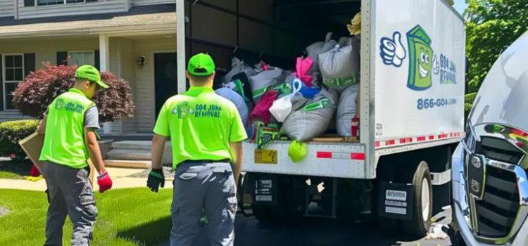 Two workers in neon green uniforms loading a truck with various bags and items in front of a suburban house. A branded company truck is parked nearby.